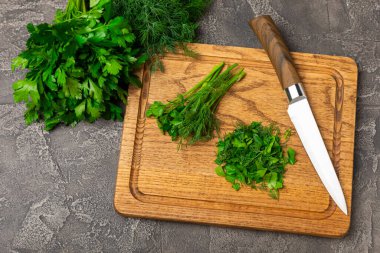 Doku masasında Dill ve Maydanoz. Maydanozla dereotu karıştırdım. Taze aromalı baharatlı sebzeler. Baharatlar ve bitkiler. Mesaj için yer var. Boşluğu kopyala