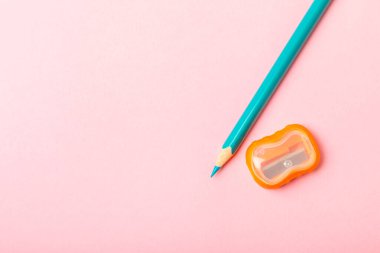 Renkli arka planda kalem açacağı. Kalem ve kalem talaşı. Kırtasiye malzemeleri. Okul malzemeleri. Okul ürünleri. Düz yatıyordu. Mesaj için yer. Boşluğu kopyala.