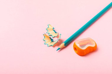 Renkli arka planda kalem açacağı. Kalem ve kalem talaşı. Kırtasiye malzemeleri. Okul malzemeleri. Okul ürünleri. Düz yatıyordu. Mesaj için yer. Boşluğu kopyala.