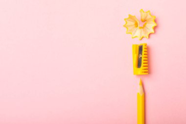 Renkli arka planda kalem açacağı. Kalem ve kalem talaşı. Kırtasiye malzemeleri. Okul malzemeleri. Okul ürünleri. Düz yatıyordu. Mesaj için yer. Boşluğu kopyala.