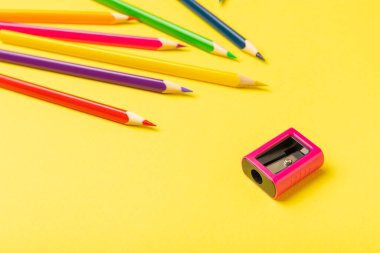 Renkli arka planda kalem açacağı. Kalem ve kalem talaşı. Kırtasiye malzemeleri. Okul malzemeleri. Okul ürünleri. Düz yatıyordu. Mesaj için yer. Boşluğu kopyala.