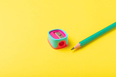 Renkli arka planda kalem açacağı. Kalem ve kalem talaşı. Kırtasiye malzemeleri. Okul malzemeleri. Okul ürünleri. Düz yatıyordu. Mesaj için yer. Boşluğu kopyala.