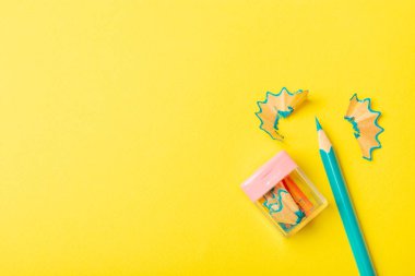 Renkli arka planda kalem açacağı. Kalem ve kalem talaşı. Kırtasiye malzemeleri. Okul malzemeleri. Okul ürünleri. Düz yatıyordu. Mesaj için yer. Boşluğu kopyala.