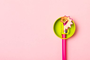 Renkli arka planda kalem açacağı. Kalem ve kalem talaşı. Kırtasiye malzemeleri. Okul malzemeleri. Okul ürünleri. Düz yatıyordu. Mesaj için yer. Boşluğu kopyala.