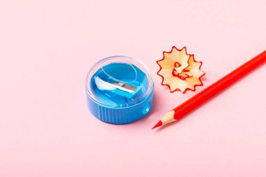 Renkli arka planda kalem açacağı. Kalem ve kalem talaşı. Kırtasiye malzemeleri. Okul malzemeleri. Okul ürünleri. Düz yatıyordu. Mesaj için yer. Boşluğu kopyala.