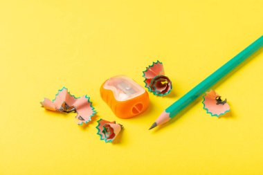 Renkli arka planda kalem açacağı. Kalem ve kalem talaşı. Kırtasiye malzemeleri. Okul malzemeleri. Okul ürünleri. Düz yatıyordu. Mesaj için yer. Boşluğu kopyala.