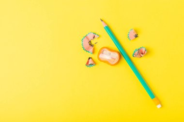 Renkli arka planda kalem açacağı. Kalem ve kalem talaşı. Kırtasiye malzemeleri. Okul malzemeleri. Okul ürünleri. Düz yatıyordu. Mesaj için yer. Boşluğu kopyala.