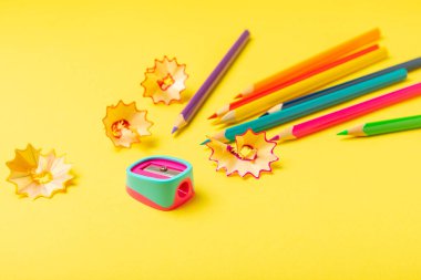 Renkli arka planda kalem açacağı. Kalem ve kalem talaşı. Kırtasiye malzemeleri. Okul malzemeleri. Okul ürünleri. Düz yatıyordu. Mesaj için yer. Boşluğu kopyala.