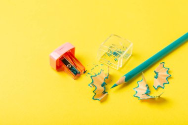 Renkli arka planda kalem açacağı. Kalem ve kalem talaşı. Kırtasiye malzemeleri. Okul malzemeleri. Okul ürünleri. Düz yatıyordu. Mesaj için yer. Boşluğu kopyala.