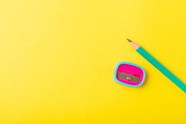 Renkli arka planda kalem açacağı. Kalem ve kalem talaşı. Kırtasiye malzemeleri. Okul malzemeleri. Okul ürünleri. Düz yatıyordu. Mesaj için yer. Boşluğu kopyala.