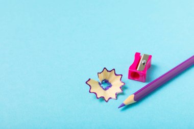 Renkli arka planda kalem açacağı. Kalem ve kalem talaşı. Kırtasiye malzemeleri. Okul malzemeleri. Okul ürünleri. Düz yatıyordu. Mesaj için yer. Boşluğu kopyala.