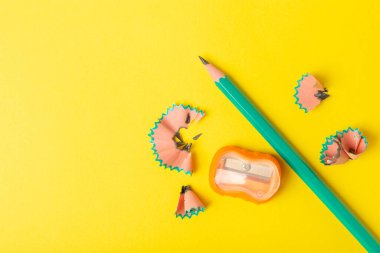 Renkli arka planda kalem açacağı. Kalem ve kalem talaşı. Kırtasiye malzemeleri. Okul malzemeleri. Okul ürünleri. Düz yatıyordu. Mesaj için yer. Boşluğu kopyala.