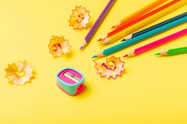 Renkli arka planda kalem açacağı. Kalem ve kalem talaşı. Kırtasiye malzemeleri. Okul malzemeleri. Okul ürünleri. Düz yatıyordu. Mesaj için yer. Boşluğu kopyala.