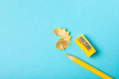 Renkli arka planda kalem açacağı. Kalem ve kalem talaşı. Kırtasiye malzemeleri. Okul malzemeleri. Okul ürünleri. Düz yatıyordu. Mesaj için yer. Boşluğu kopyala.