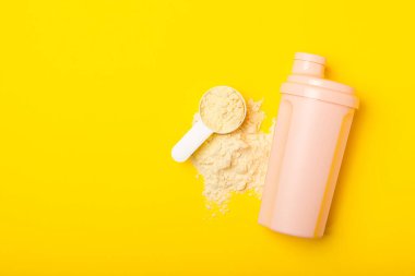 Protein karışımı ve renkli bir arka planda protein tozu. Toz su veya sütle karıştırılır. Dengeli bir diyet için diyet takviyesi. Beyaz protein. Fitness ve jimnastik diyeti.