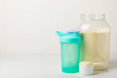 Protein karışımı ve renkli bir arka planda protein tozu. Toz su veya sütle karıştırılır. Dengeli bir diyet için diyet takviyesi. Beyaz protein. Fitness ve jimnastik diyeti.