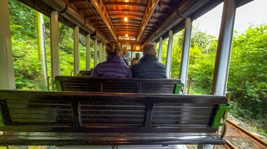 Ramsey, Man Adası 08.05.2023 treninde oturanlar var. Tren hareket ediyor ve insanlar pencereden dışarı bakıyor Man Adası -