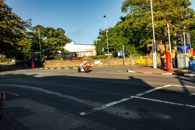 Douglas, Man Adası 08.05.2023 Motosikletli Adam yolda ilerliyor. Onu izleyen birkaç kişi var. Sahne sakin ve huzurlu Man Adası -