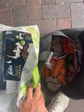 Douglas, Man Adası 08.05.2023 kişi üzerinde kedi olan bir çanta ve bir kutu Felix Shredded tutuyor. Man Adası -