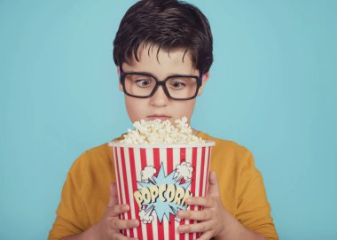 mavi arka plan üzerinde patlamış mısır ile küçük çocuk çocuk