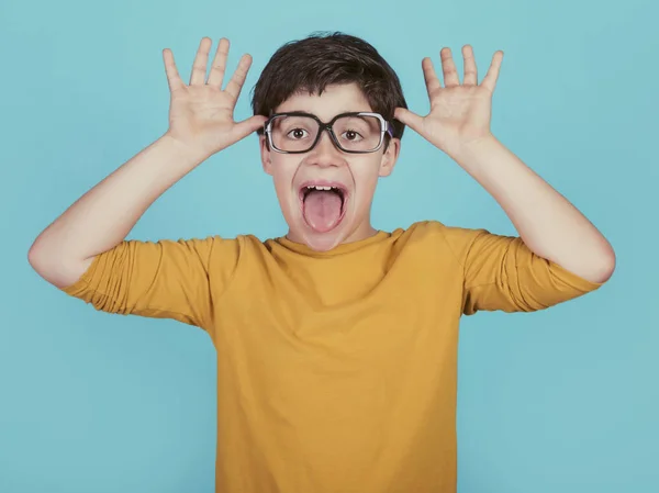 Rolig Pojke Med Glasögon Visa Tungan Blå Bakgrund — Stockfoto