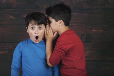 Ahşap arka plan üzerinde gizli fısıldayan iki erkek portresi