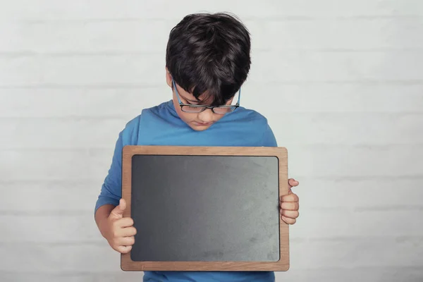 child with a blackboard on brick background