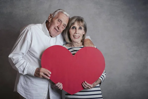 Ritratto Coppia Anziana Felice Con Cuore Rosso Sfondo Grigio — Foto Stock