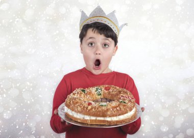 surprised child with King cake typical spanish dessert for Christmas clipart