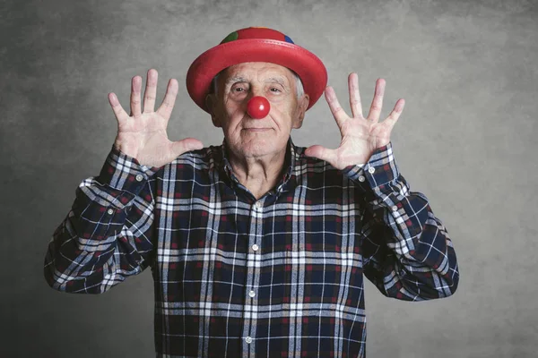 funny grandfather with hat and clown nose on gray background