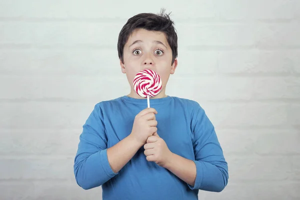 Niño Sorprendido Con Piruleta Sobre Fondo Ladrillo — Foto de Stock