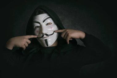 adam siyah arka plan üzerinde anonim maskeleme ile gülümseyen