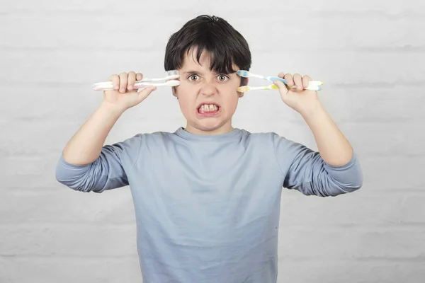 Arg kille som spelar t vill rengöra tänderna — Stockfoto