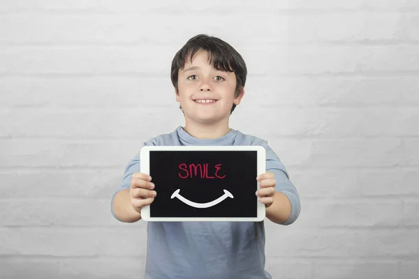 Sonríe, niño feliz sosteniendo una tableta — Foto de Stock