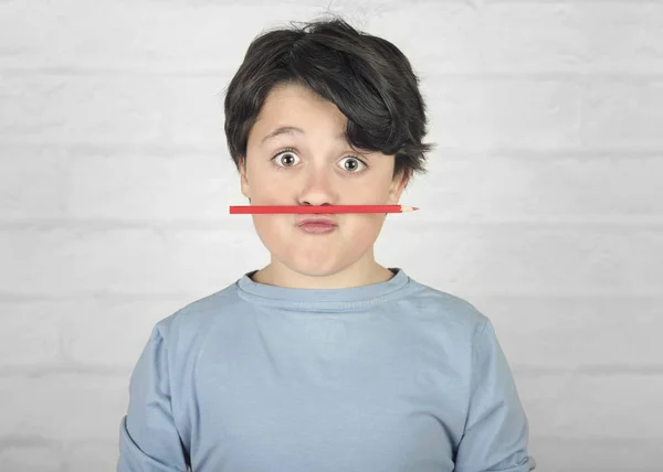 Roligt barn med färgad penna i munnen — Stockfoto