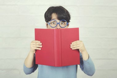 bir kitap tutan gözlük ile sürpriz çocuk
