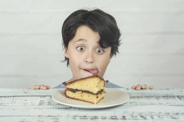 Niño hambriento comiendo pedazo de pastel — Foto de Stock