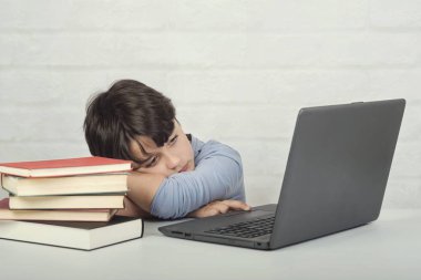 dizüstü bilgisayar ve kitap ile üzgün çocuk