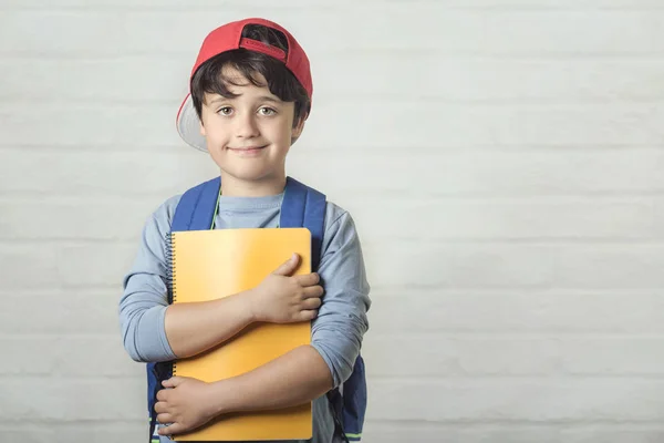 Niño feliz con mochila y con cuaderno, de vuelta a la escuela — Foto de Stock