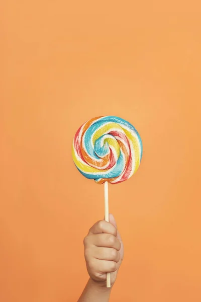 Mano de niño con piruleta colorida — Foto de Stock