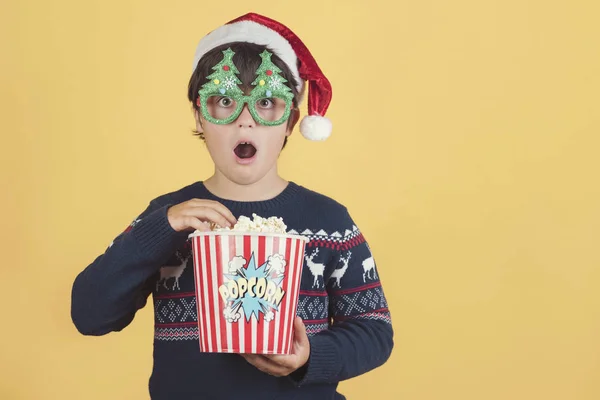 Niño sorprendido usando sombrero de Navidad con palomitas de maíz — Foto de Stock