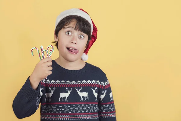 Niño vistiendo Navidad Santa Claus sombrero y bastones de caramelo — Foto de Stock