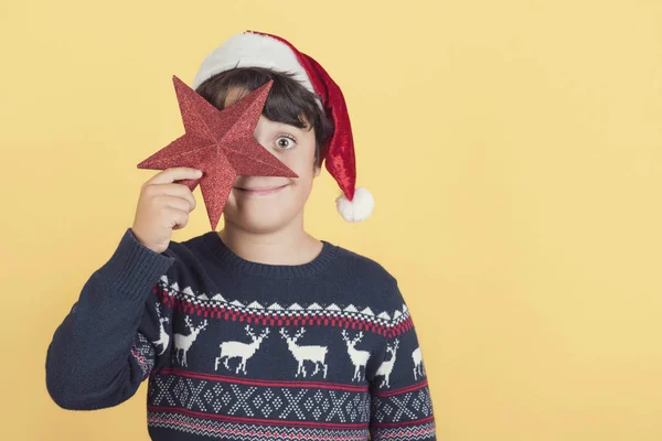 Sjovt barn, der dækker et øje med julestjerne - Stock-foto