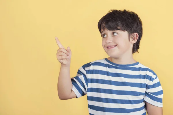 Barn leende pekar med hand och finger upp till sidan med Happy Expression — Stockfoto