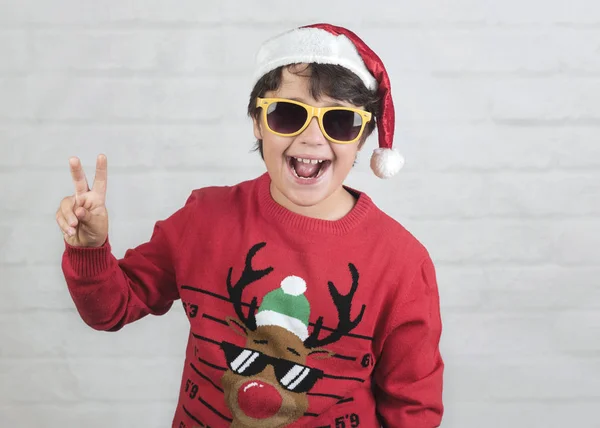 Leende barn bär Christmas Santa Claus hatt med solglasögon — Stockfoto
