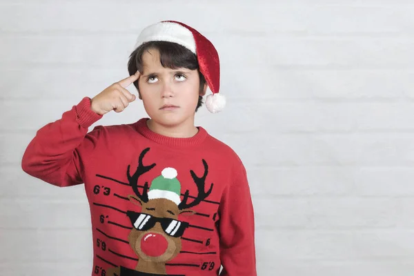 Niño reflexivo usando Navidad Santa Claus sombrero — Foto de Stock