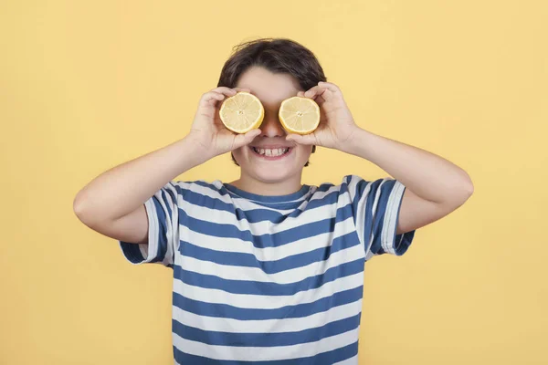 Tersenyum anak memegang lemon di matanya — Stok Foto