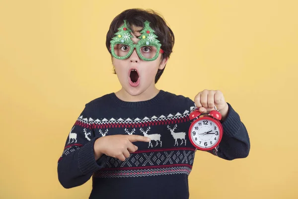 Niño sorprendido con reloj despertador con gafas de Navidad divertidas — Foto de Stock