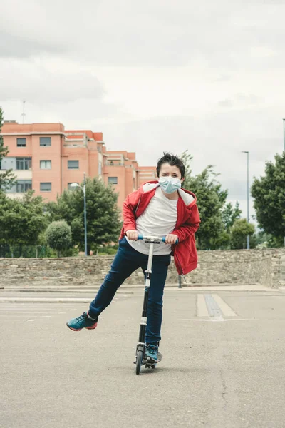 Niño Feliz Usando Máscara Médica Con Scooter Ciudad Aire Libre — Foto de Stock