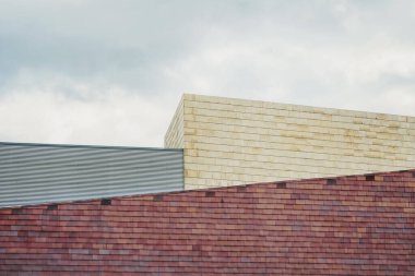 Bulutlu mavi gökyüzü ve farklı binalar.